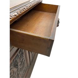 Victorian heavily carved oak sideboard, the moulded top carved with foliate decoration to the edge, fitted with two drawers and three cupboards, the drawer fronts carved with green man mask handles and scrolling foliage, the panelled doors carved with interlacing foliage, on turned compressed bun feet