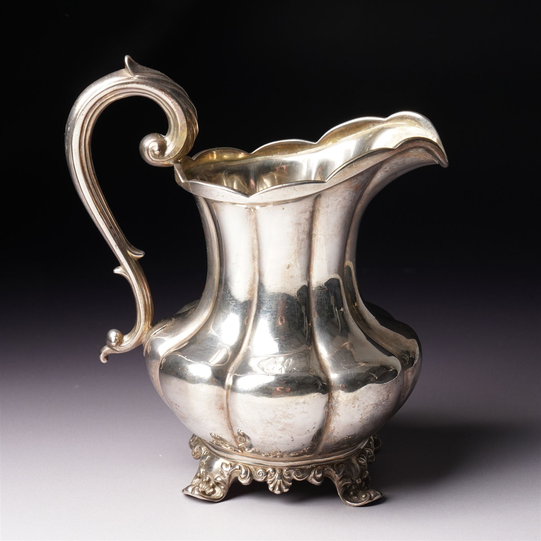 Victorian silver cream jug of panel sided baluster form with crimped rimand scroll handle on shaped supports London 1840 Maker Charles Gordon  