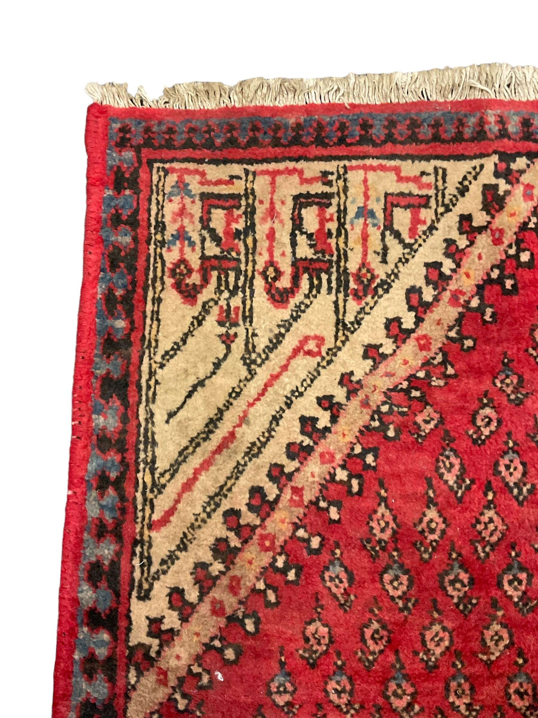 Small Persian red ground rug, lozenge medallion surrounded by small Boteh motifs