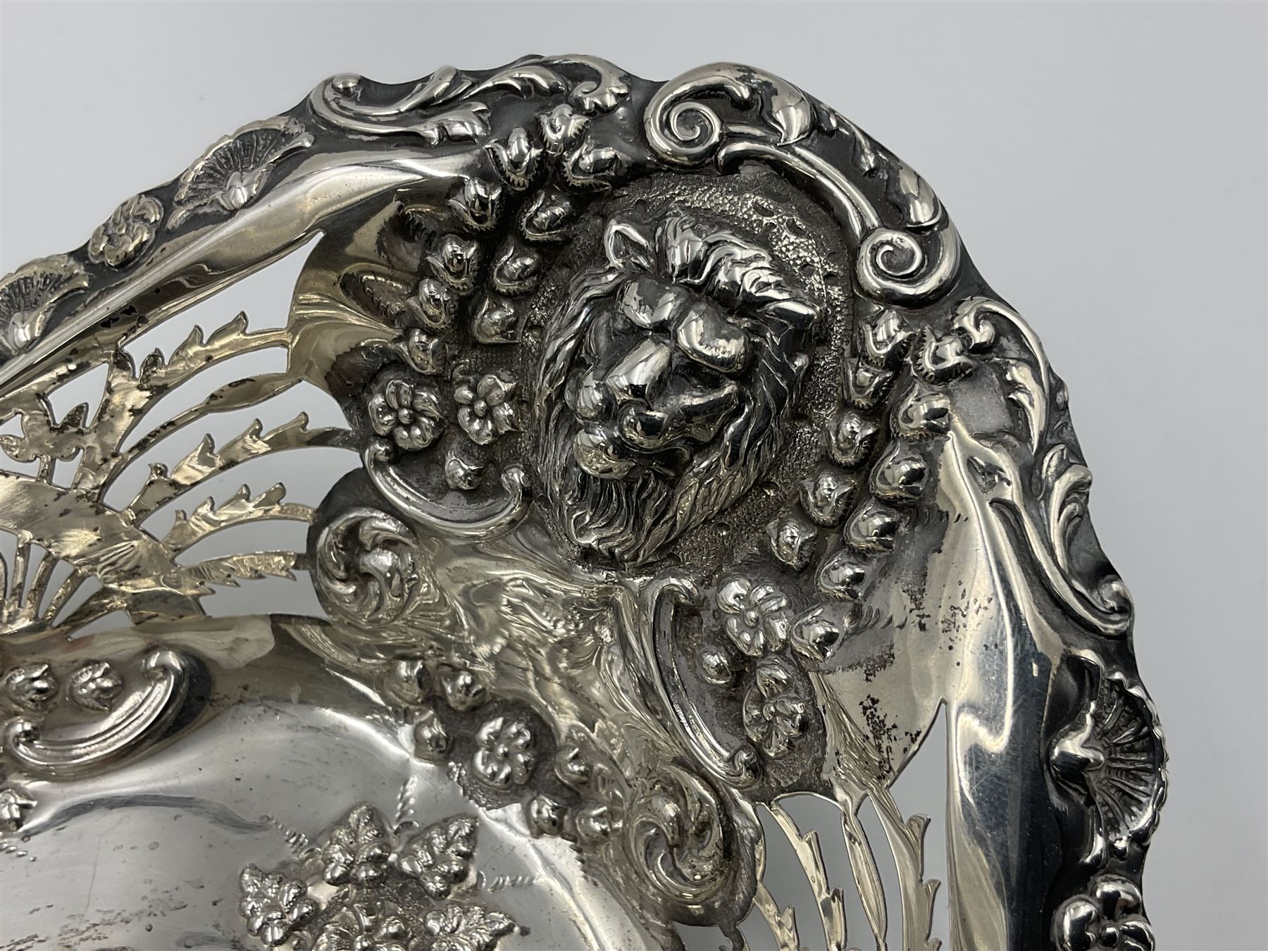 Edwardian silver swing handled basket, of navette form, with four repousse lion masks to each corner and with pierced and embossed floral, scroll and shell decoration to sides, base and handle, hallmarked Charles Horner, Birmingham 1906, height including handle H20cm