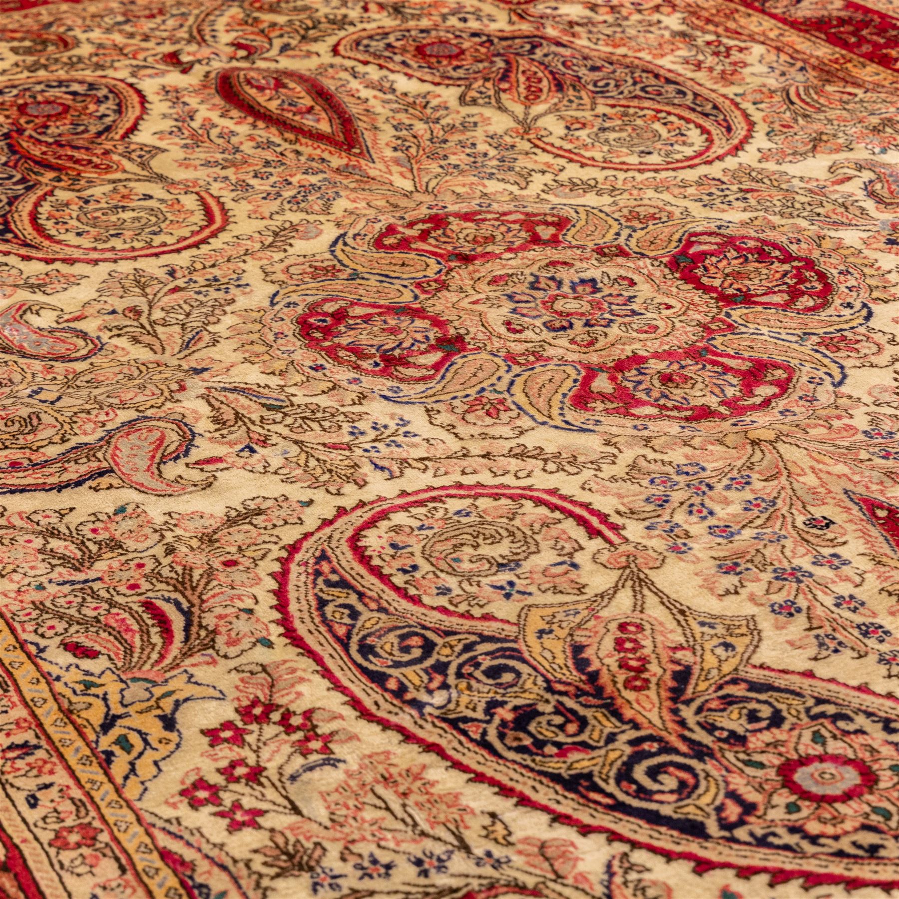 West Central Persian Sarouk hand-knotted carpet, ivory field with central ornate medallion and scrolling vines and palmettes, surrounded by large stylized boteh motifs and flowering foliage, enclosed by a madder-red border of palmettes and floral vine ornament between multiple guard stripes, cotton fringe ends 
