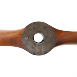 Aviation design two-blade mahogany propeller, shaped blades with black painted ends, central mounting aperture within a circular six-bolt metal hub plate