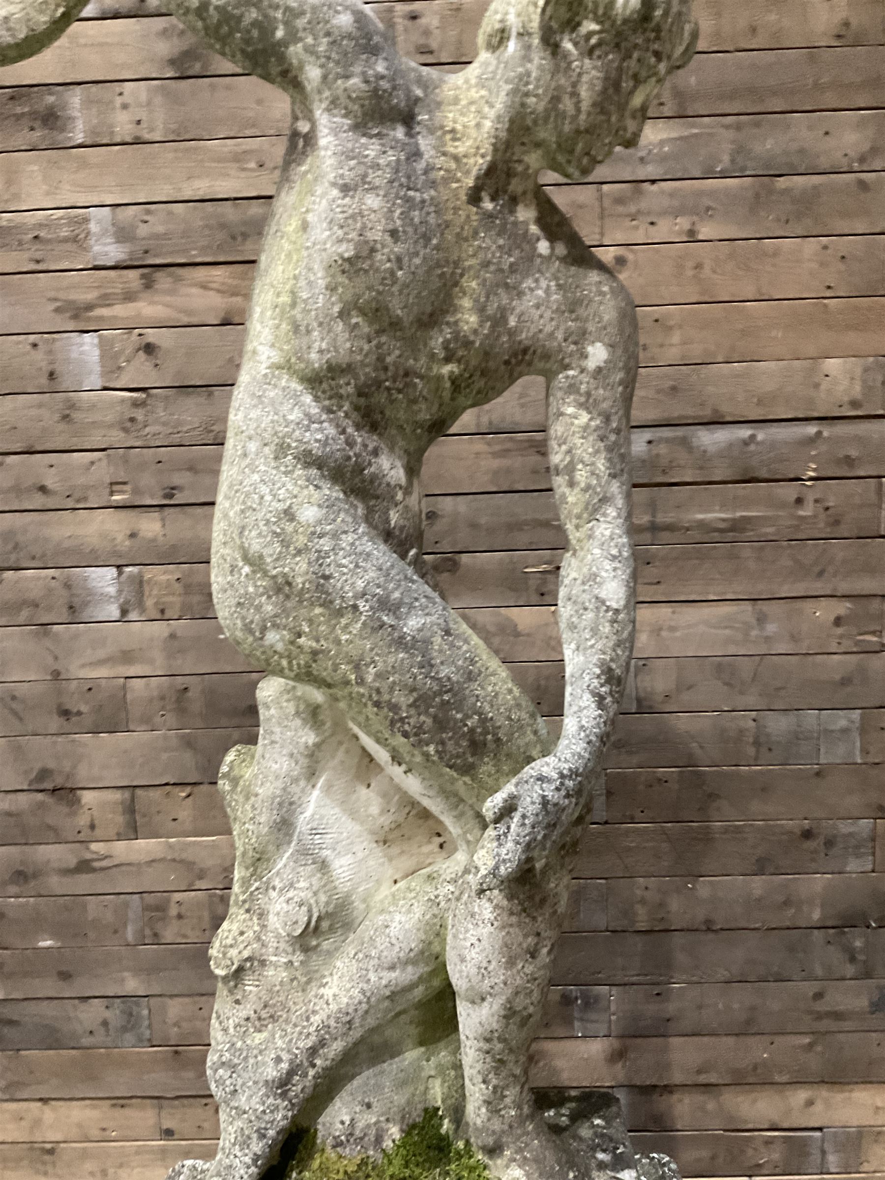 Life-size weathered cast stone Greek Discus Athlete, seated on rectangular slab raised on associated architectural plinth