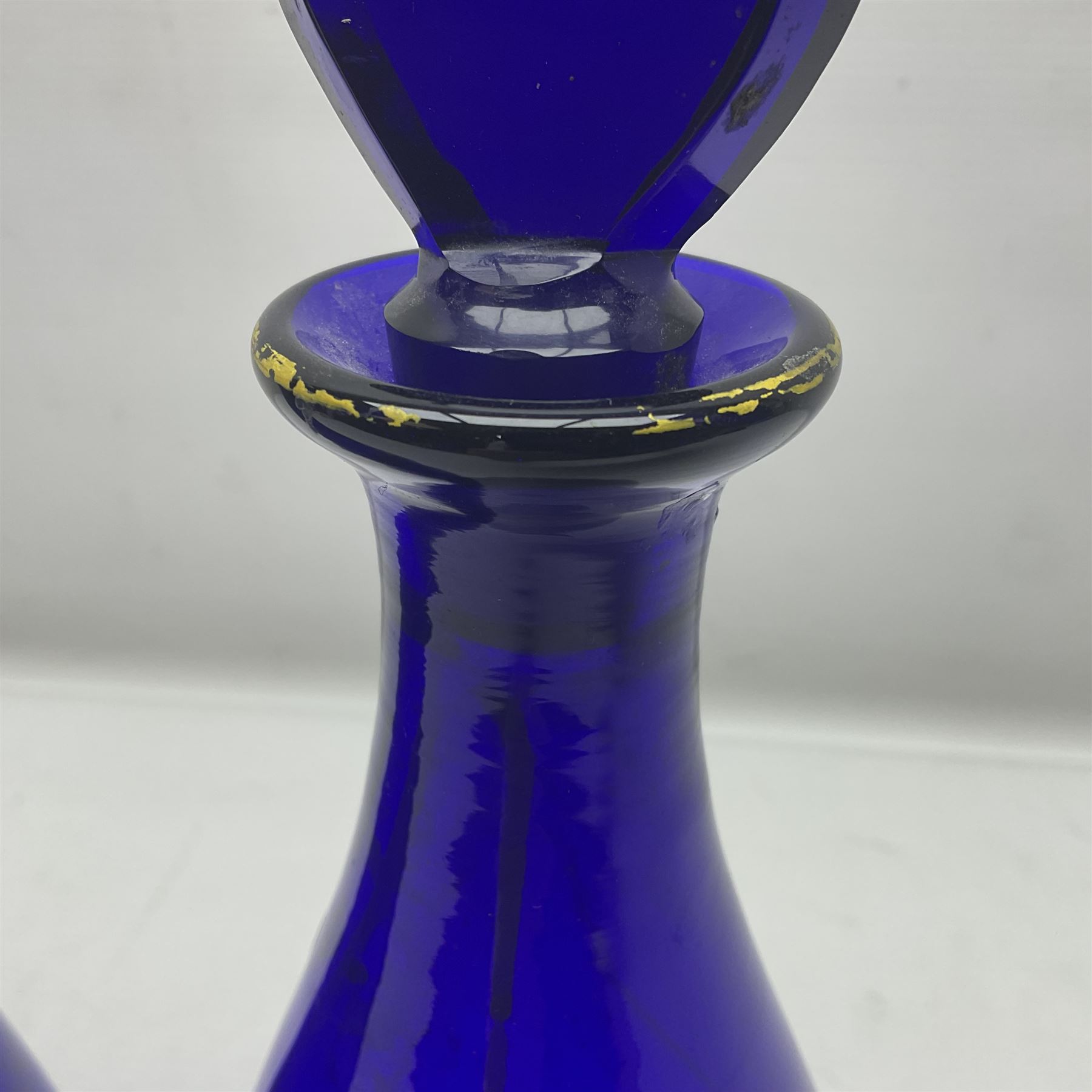 Pair of early 19th century blue glass decanters with teardrop stoppers, with gilt writing, the first marked Gin the second Brandy 