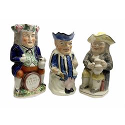 Three 19th Century Toby jugs, comprising an example straddling a barrel inscribed 'Home Brewed Ale', another modelled as a seated jester, and a further with a tricorn hat lid seated with a jug of ale, max H27cm