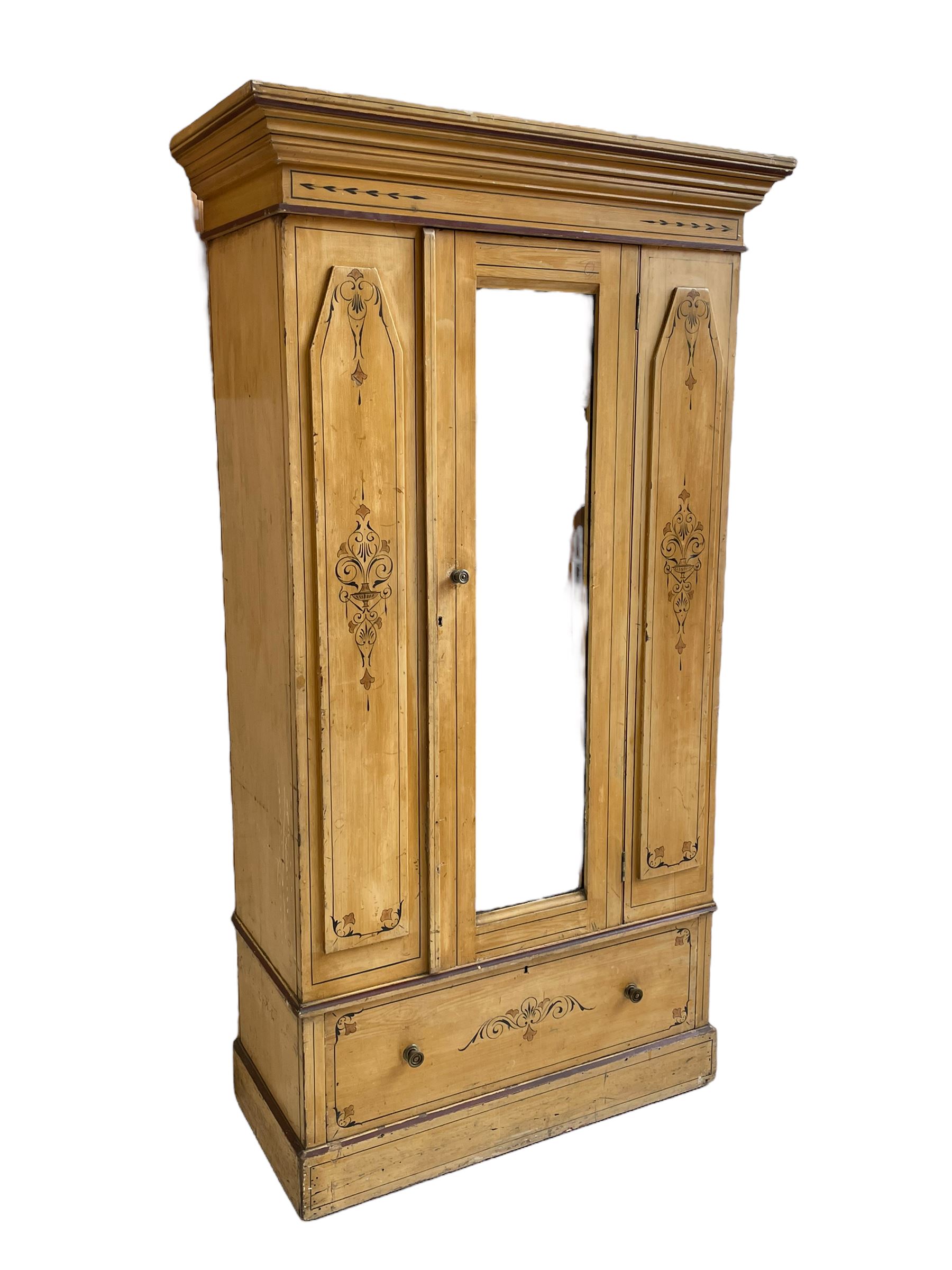 19th century painted pine wardrobe, the projecting cornice over mirror glazed door, with painted decoration depicting scrolling foliate and urns, drawer to base on skirt