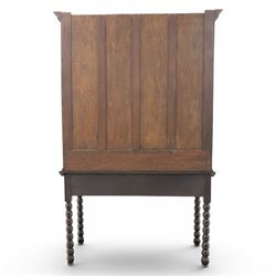 Early 20th century Jacobean Revival dark stained oak dresser, the associated upper section enclosed by twin glazed doors with shaped moulded glazing bars, over separate base fitted with two drawers, raised on bobbin turned legs
