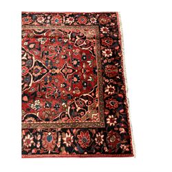 Persian Hamadan rug, red ground, the field decorated with central medallion and stylised flower motifs, repeating border 