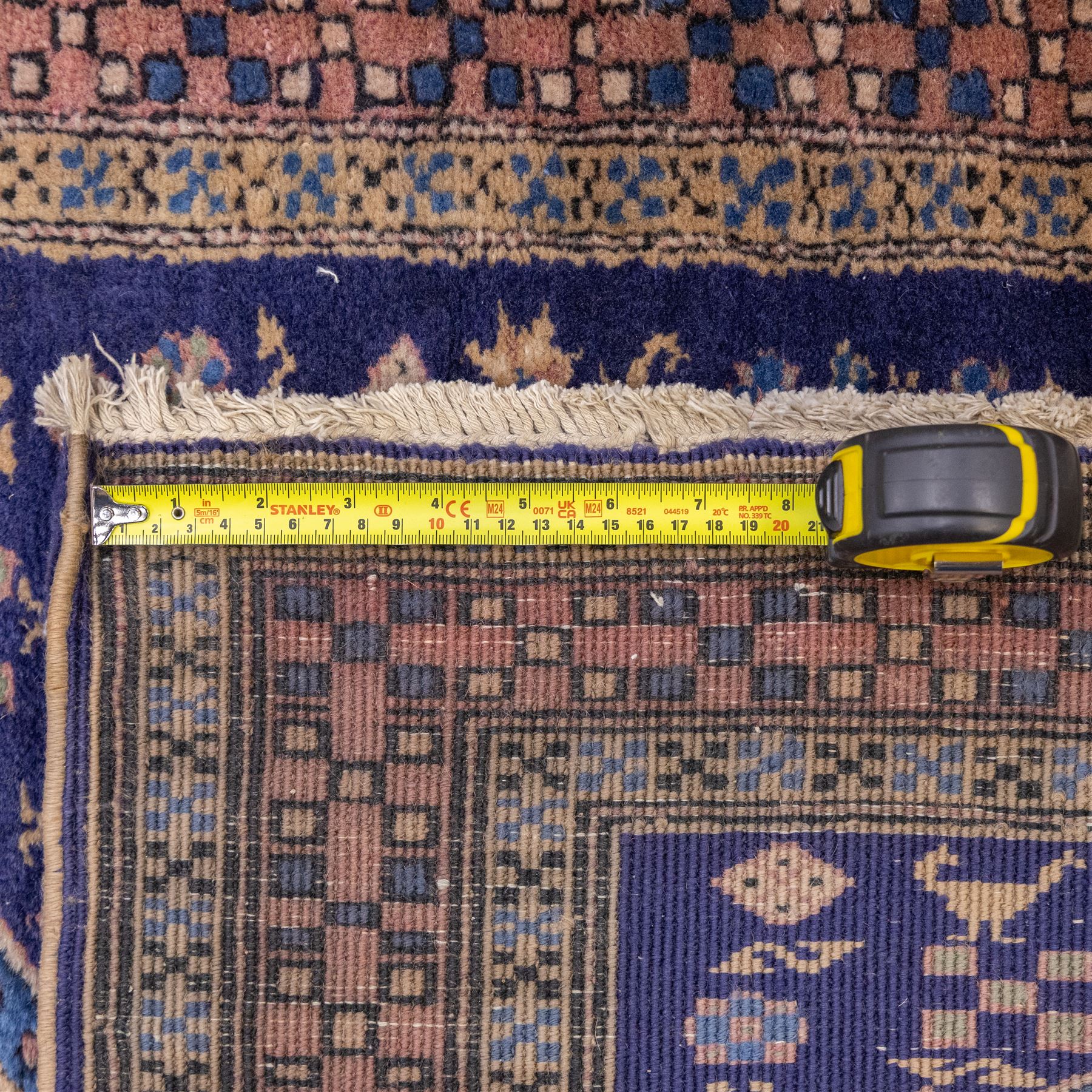 North West Persian Ardebil hand-knotted runner, indigo field composed of a vertical series of large linked hexagonal medallions alternating soft terracotta and sage-green grounds, medallions connected narrow waist panels, surround field filled with geometric devices on a pale blue ground, principal border decorated with a repeating geometric and floral motif on a light ground flanked by narrow guard stripes incorporating small rosettes, with cotton fringe ends 