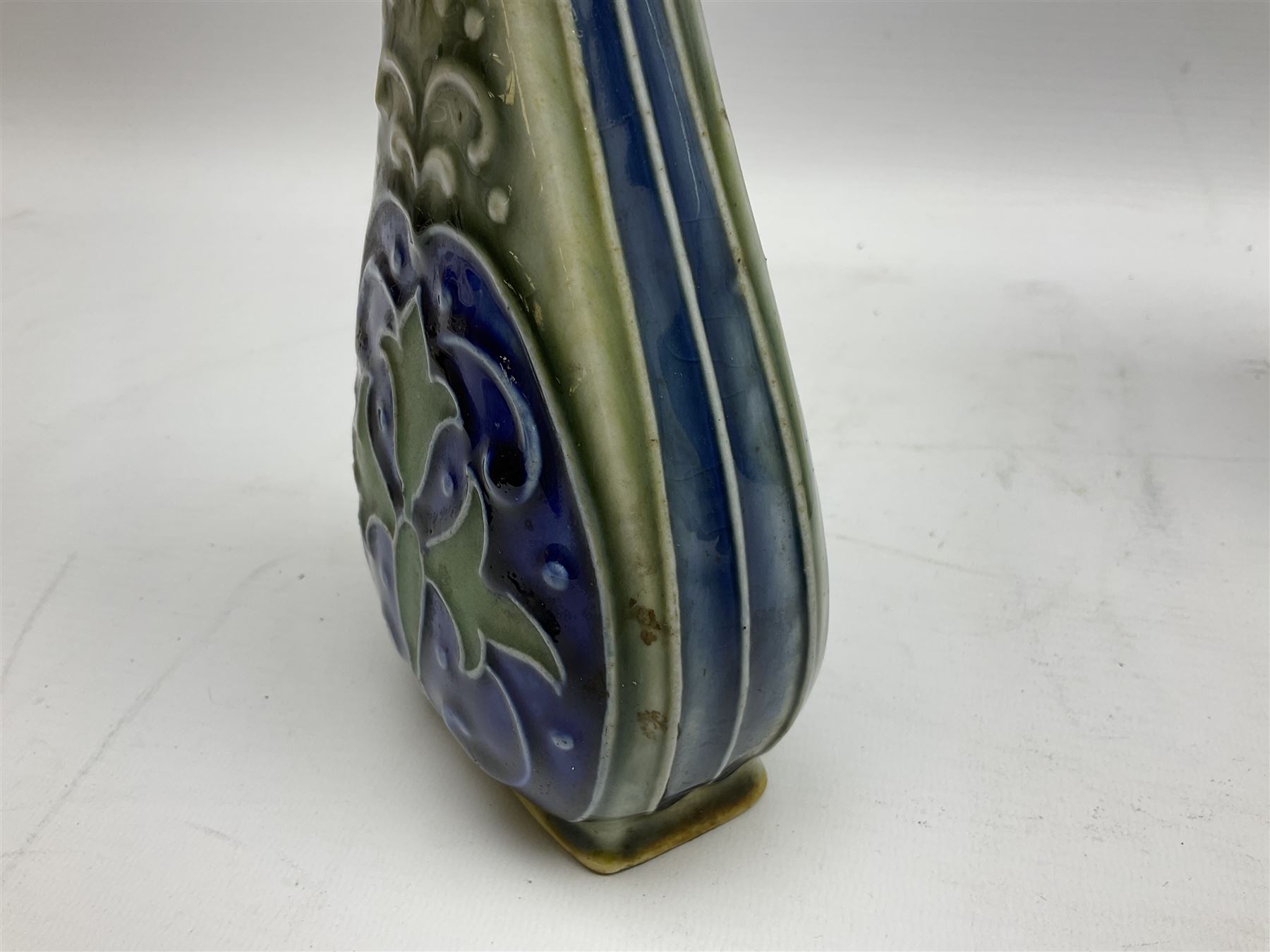 Two Royal Doulton stoneware vases, the first example with tubelined floral decoration, the second with Art Nouveau decoration, together Doulton Lambeth vase of flattened form with foliate decoration on a green ground, all with impressed mark beneath, tallest example H26cm