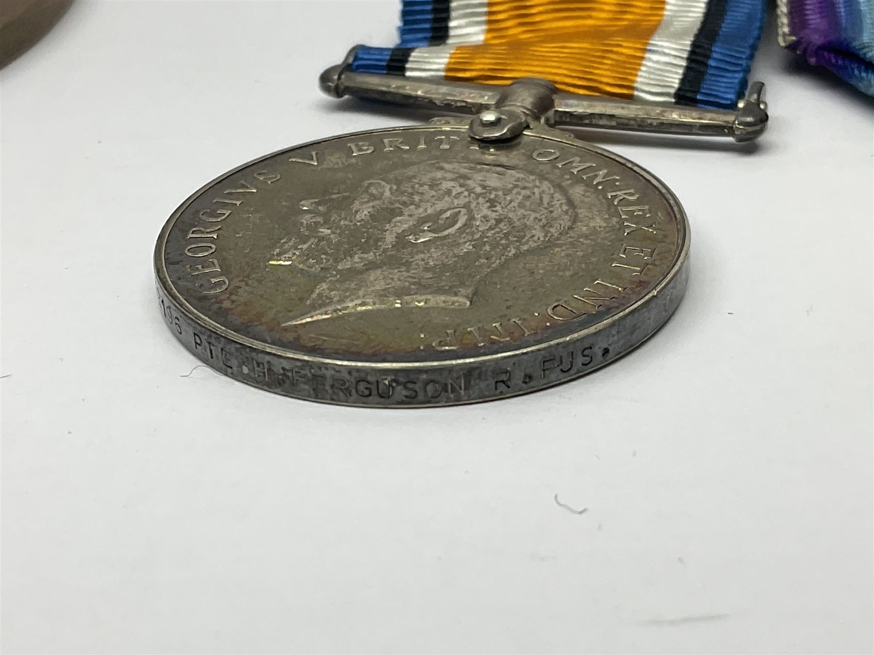 WWI pair of medals comprising British War Medal and Victory Medal awarded to G/62196 Pte. H. Ferguson R. Fus. with ribbons on wearing bar; together with bronze memorial plaque to Henry Ferguson (3)