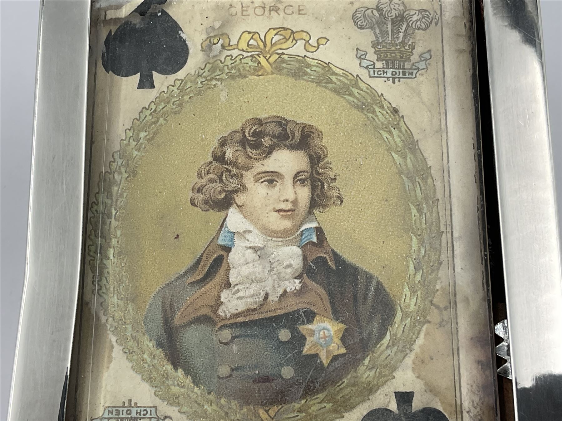 Edwardian silver mounted playing card case, hallmarked William Harrison Walter, Birmingham 1903, the sides each with a period playing card set behind a bevelled glass panel, the hinged cover with later engraving 'Presented to Norman T Crombie Esq by the officers & men of the 31st WR Detachment for services rendered 1917-1918', with red leather lined interior, the three compartments upon a sprung base and containing two later wooden Whist markers, case H12.5cm