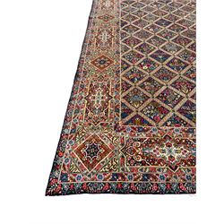 Persian Kirman indigo ground carpet, the field with repeating lozenge tiles with overall floral decoration, the main border with floral panels enclosed by the guards