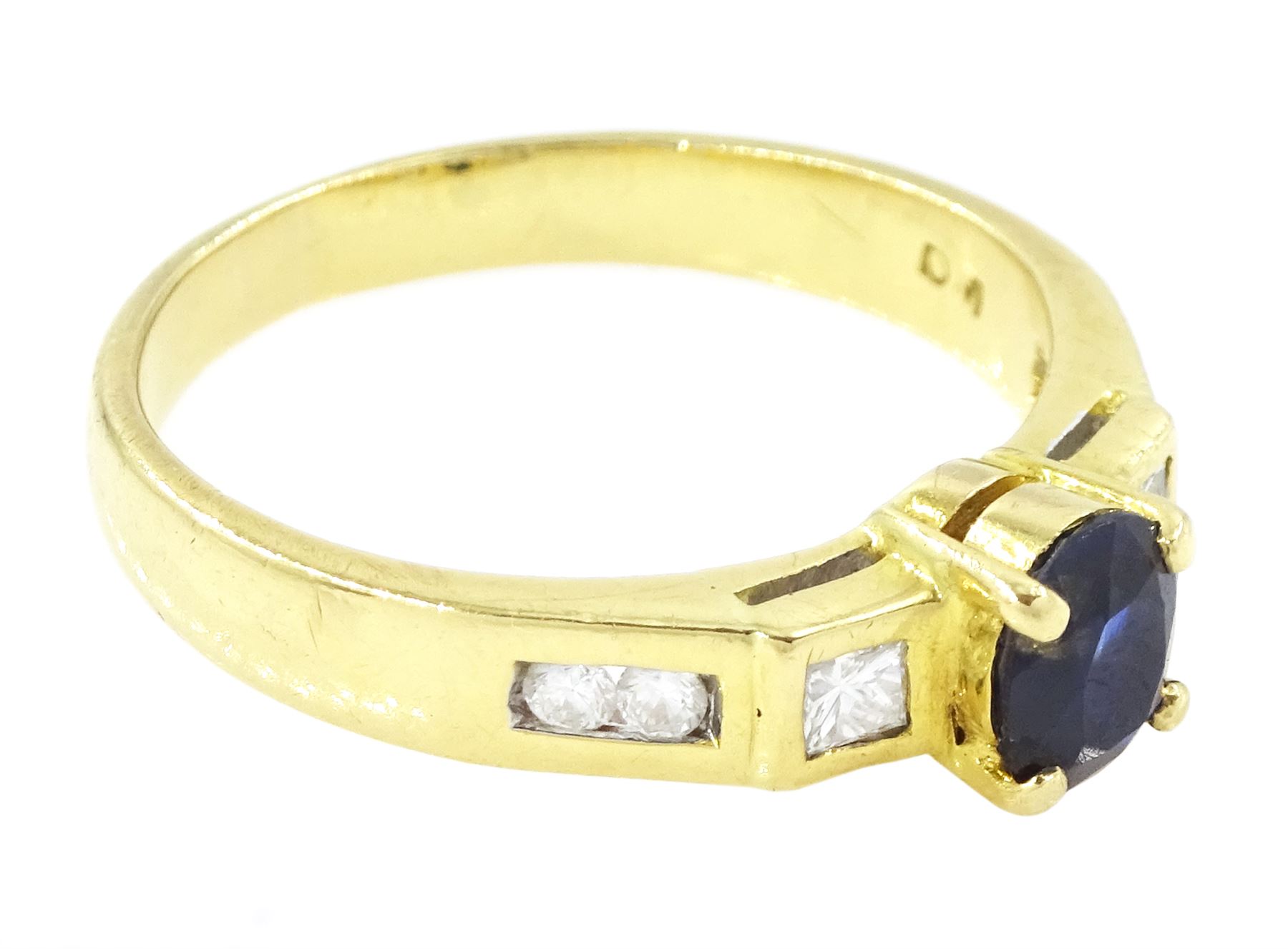 18ct gold sapphire and diamond ring, single oval cut sapphire of approx 0.70 carat, with a princess cut diamond and two round brilliant cut diamonds set either side, stamped 750, total diamond weight approx 0.20 carat