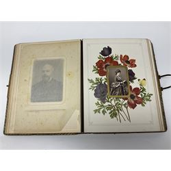  Victorian leather bound photo album, the interior leaves containing apertures of various sizes and shapes of portraits surrounded by printed floral designs, with brass clasp and painted gold decoration to edges, H30cm