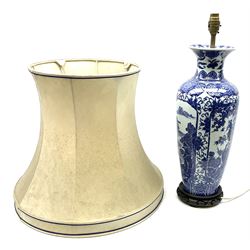 A Chinese blue and white table lamp, of slender baluster form decorated with alternate panels of landscapes and phoenix amongst blossoming peony and prunus trees, with fabric shade, lamp base H46.5cm.