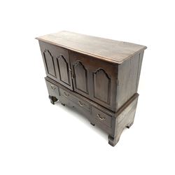 Georgian and later oak mule chest, fitted with two panelled cupboard doors enclosing shelving above two short drawers flanking central long drawer, shaped apron, raised on shaped bracket supports 