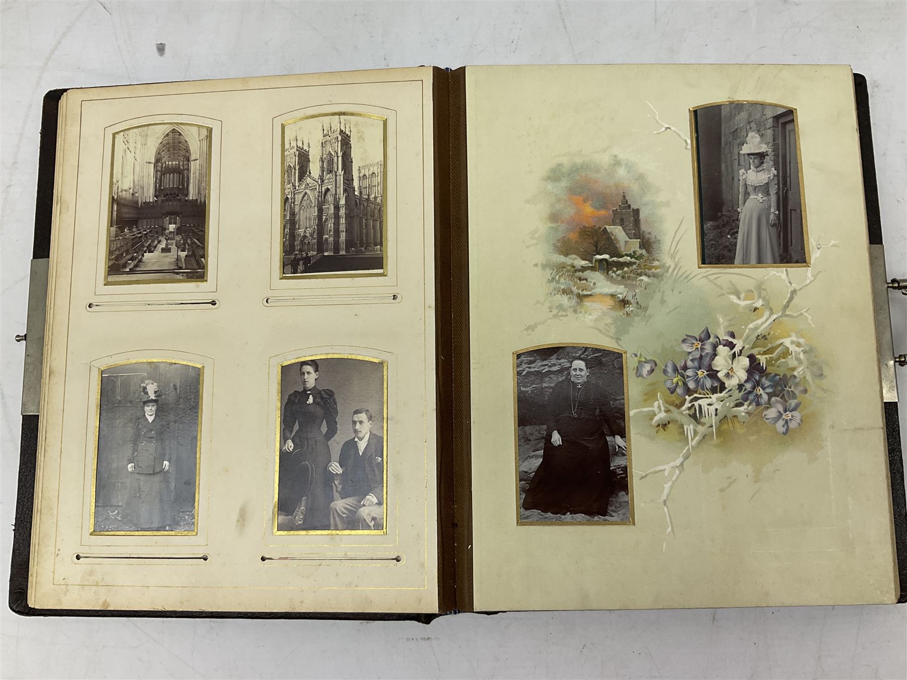 Victorian leather bound photo album, the interior leaves containing apertures of various sizes and shapes of portraits surrounded by printed floral designs, H28cm