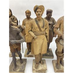 Seven 19th Century Indian clay dolls, possibly Krishnanagar, each figure with painted details, wearing cloth garments, standing on rectangular bases, some with paper label to the base, H25cm