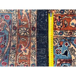 Northeastern Persian Meshed carpet, the deep navy field with a symmetrical floral arrangement of stylised flowerheads, palmettes and scrolling vines issuing from a central urn, enclosed by broad rust and blue borders of floral arabesques and lotus forms, from the region of Meshed