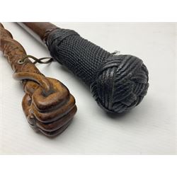 19th century wooden walking stick, the handle carved as a snake within a clenched fist, the cane carved with foliate and cross hatched decoration, with a metal spike to base, together with a turned wooden walking stick, with lacquered rope nautical knot handle, tallest L96.5cm