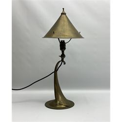 Arts & Crafts Jesson, Birkett & Co, brass table lamp or wall light, designed by Thomas Birkett, the tapering stem with adjustable ball pivot supporting a conical shade with tapering final with ball terminal, upon a circular domed base pierced for wall mounting, shade positioned upright overall H57cm

Often misattributed to Arthur Stansfield Dixon for Birmingham Guild of Handicraft, this particular lamp was designed by Thomas Birkett.
In the late 1890's Birkett worked as a metalwork at the Birmingham Guild, before later joining the Faulkner Bronze Company which went on to become Jesson, Birkett & Co in 1904. The lamp features in lighting catalogues from the firm under the model no E490.

