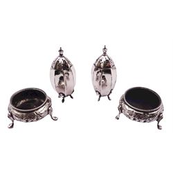 Pair of Victorian silver open salts of cauldron form, each with embossed flower head decoration and beaded rim, upon three hoof feet, hallmarked London 1882, probably Henry Holland, together with a pair of 20th century silver peppers, of faceted form, upon four pad feet, hallmarked E J Houlston, Birmingham 1917 or 1942, approximate total weight 4.60 ozt (143.3 grams)
