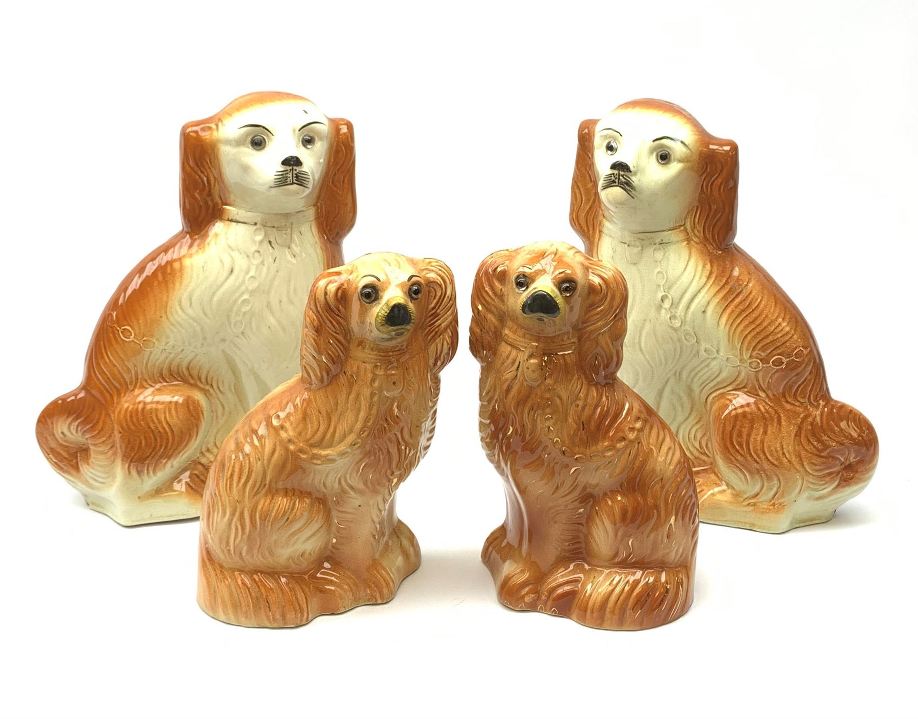 A pair of large 19th century Staffordshire dogs with glass eyes, H34cm, together with another smaller pair with glass eyes, H26.5cm, each in the form of a spaniel with russet coat. (4). 