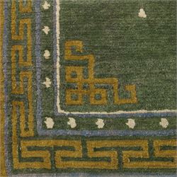 Chinese Ningxia rug, green field with central stylized shou medallion and scattered cloud motifs within key fret borders in shades of olive green, fringe ends partially detached 