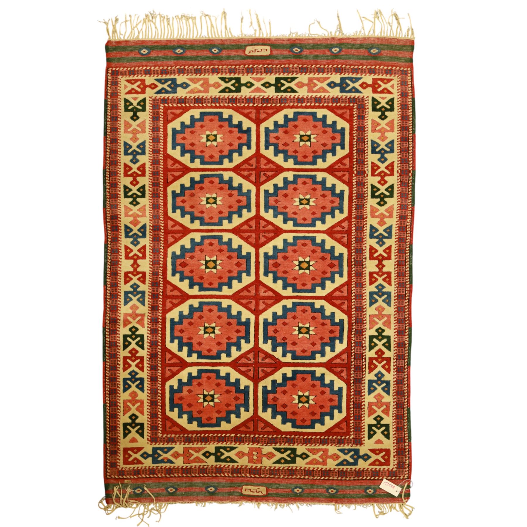 Anatolian Soumak rug, ivory ground decorated with a grid of eight octagonal medallions in terracotta red outlined in blue, centered with a star motif in vertical rows, framed by a series of geometric borders in ivory, green, and blue, incorporating hooked devices and stylized lozenges and stripped end panels, with signature at either end 