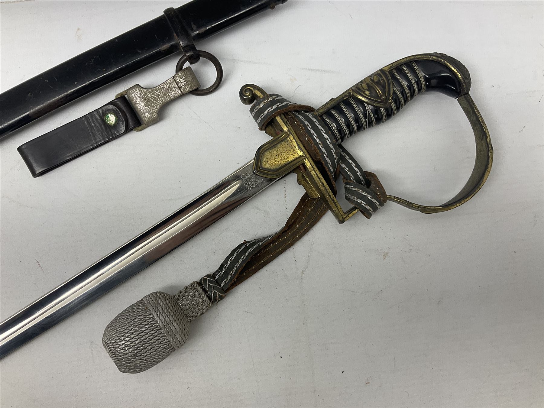 WW2 German Army Prinz Eugen Pattern Officers Dress Sword by Carl Eickhorn, the 80.5cm slightly curving fullered blade with makers name to the ricasso, gilt brass hilt with eagle to the cross-piece and relief of oakleaves to the ferrule, Prinz Eugen style down winged eagle to the pommel of the backstrap; grip retains the original wire binding; in original black painted scabbard with single hanging ring, leather hanger marked 'RZM M5/71 OLC' and silvered knot L97cm overall