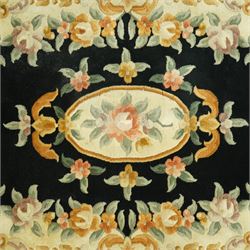 Chinese Aubusson design wool rug, black field with a central oval floral medallion framed by a wide border of scrolling flowers and foliage in soft pastel tones, with ivory spandrels and cotton fringe ends 