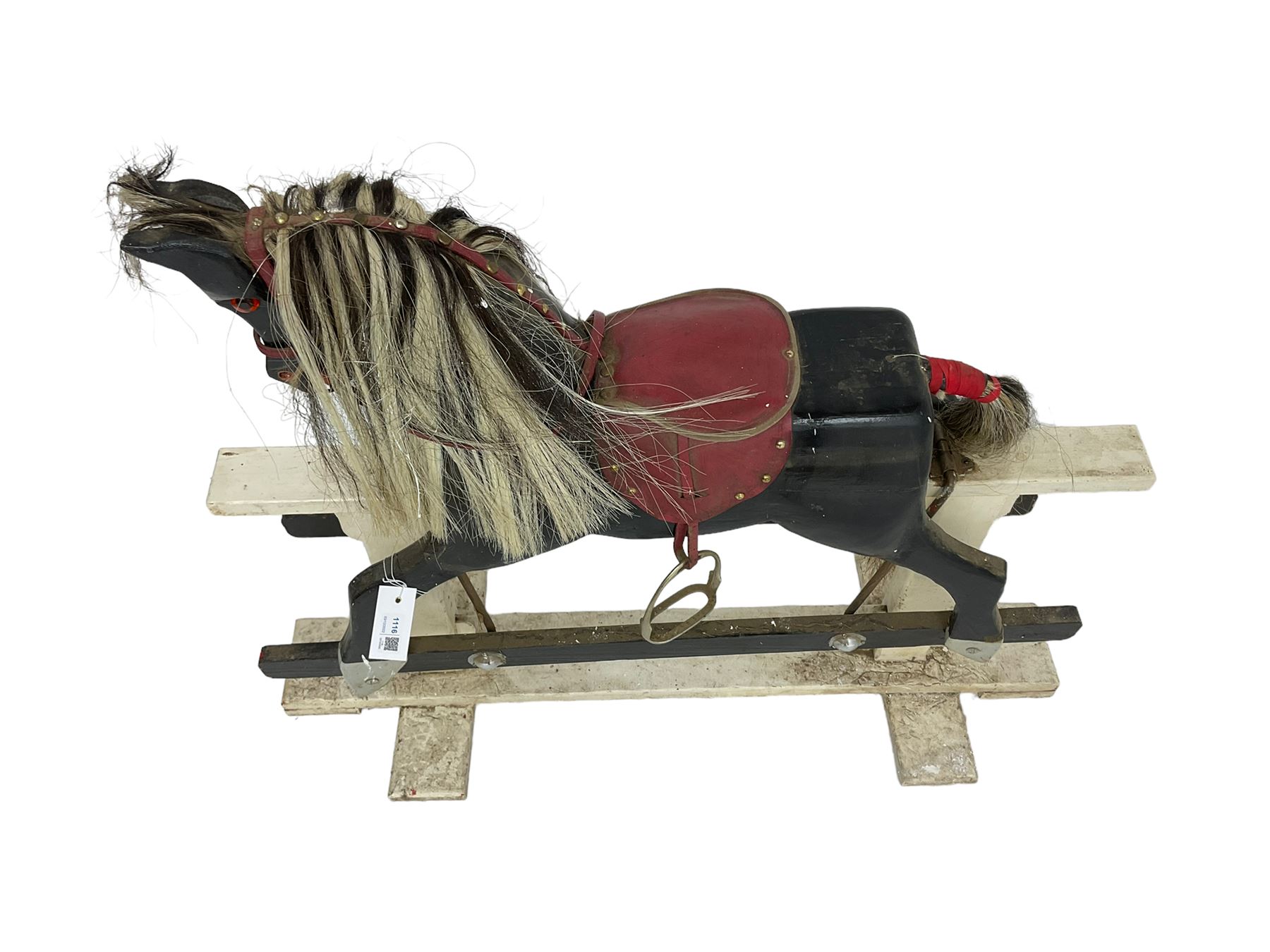 20th century black painted rocking horse on white painted trestle base, fitted with saddle and stirrups 