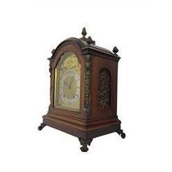 Eearly 20th century German mahogany cased bracket clock with an eight-day going barrel movement striking the quarters on two gongs and hours on one, in a break arch case surmounted with brass pineapple finials, silk backed pierced brass sound frets, canted brass caryatids and raised on outward scrolled feet, conforming break arch dial with a silver chapter ring, spandrels, steel fleur di Lis hands and matted dial centre. With key and pendulum.