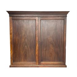 George III mahogany Gentleman's linen press, the projecting cornice over two panelled cupboard doors enclosing three sliding trays, the base fitted with two short over three long graduating cock-beaded drawers, lower moulded edge over bracket feet