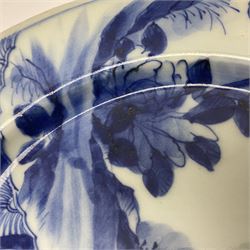 Japanese Meiji period Arita blue and white plate, of circular form, painted with riverside landscape and bird upon flowering branch, with character mark beneath, D24.5cm, together with two 18th century Chinese blue and white plates, each painted with floral design, each approximately D22.5cm
