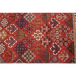 Collection of four Persian rugs, comprising a Saraband ivory ground rug with all-over boteh field and multiple borders; a crimson ground Hamadan type rug with all-over stylised floral and geometric motifs; a floral medallion prayer rug with dark field and ivory spandrels; and a Hamadan peach ground rug with repeating stylised flowering plants and dark multiple borders, largest 83cm x 142cm