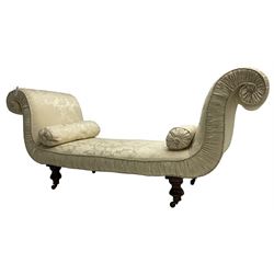 Victorian mahogany framed window seat day bed, the scrolled arms and seat upholstered in ivory foliate patterned damask fabric with matching ropetwist piping, raised on turned supports with castors