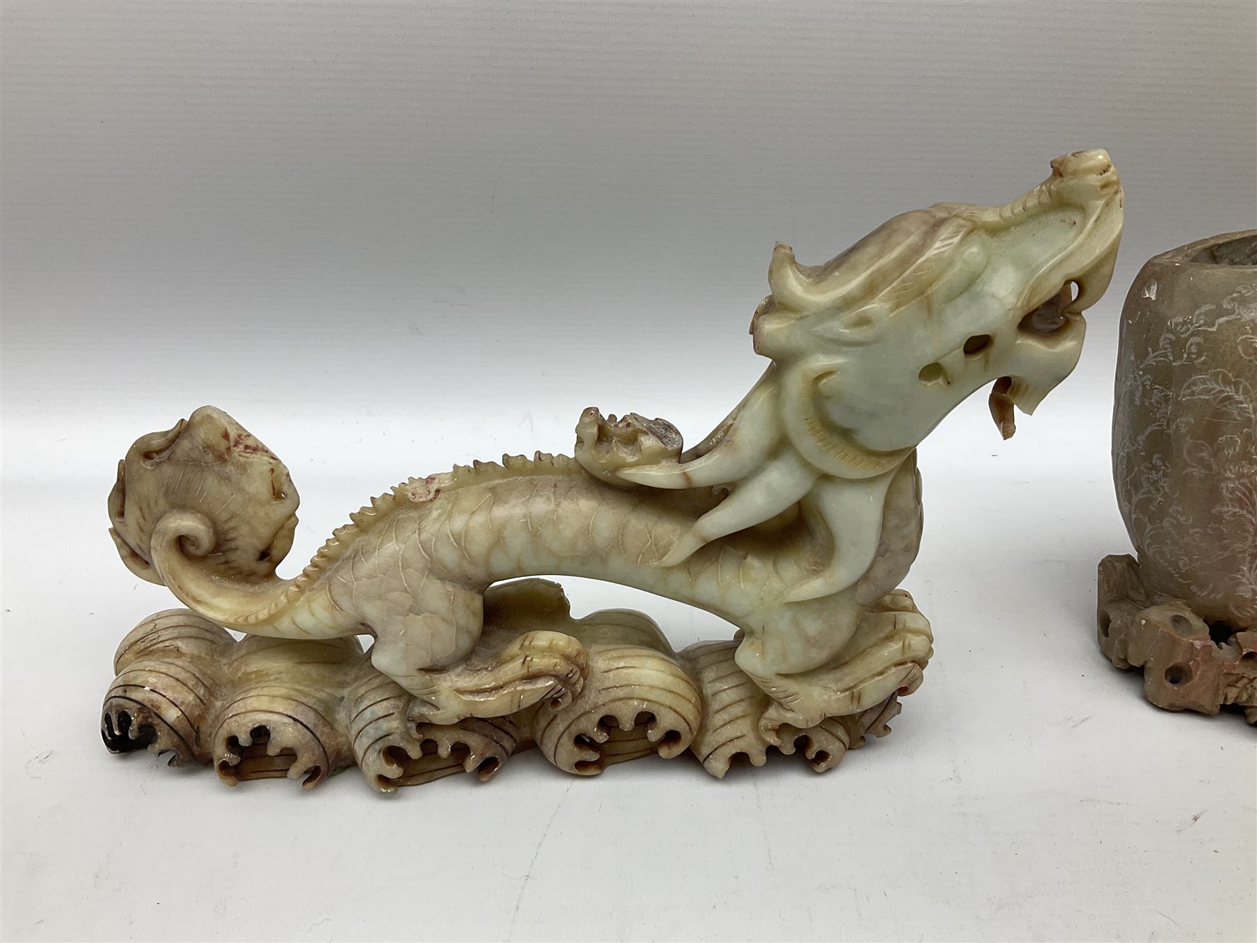 Three soapstone carvings, to include three toed dragon example, carved example with monkeys and another similar, together with carved wood figure, largest L29cm 