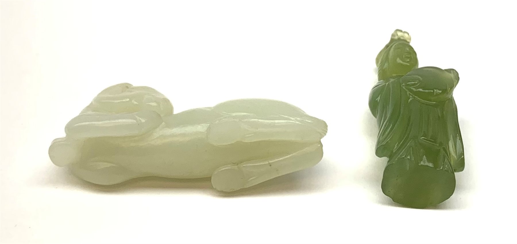 A Chinese celadon jade carved figure, modelled as a recumbent horse, L6cm, together with a nephite jade carved figure modelled as Guanyin, H5.5cm. 
