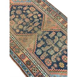 Old Persian rug, the field with two interlinked indigo ground medallions decorated with Herati motifs, the border decorated with repeating stylised flower head motifs within guard stripes