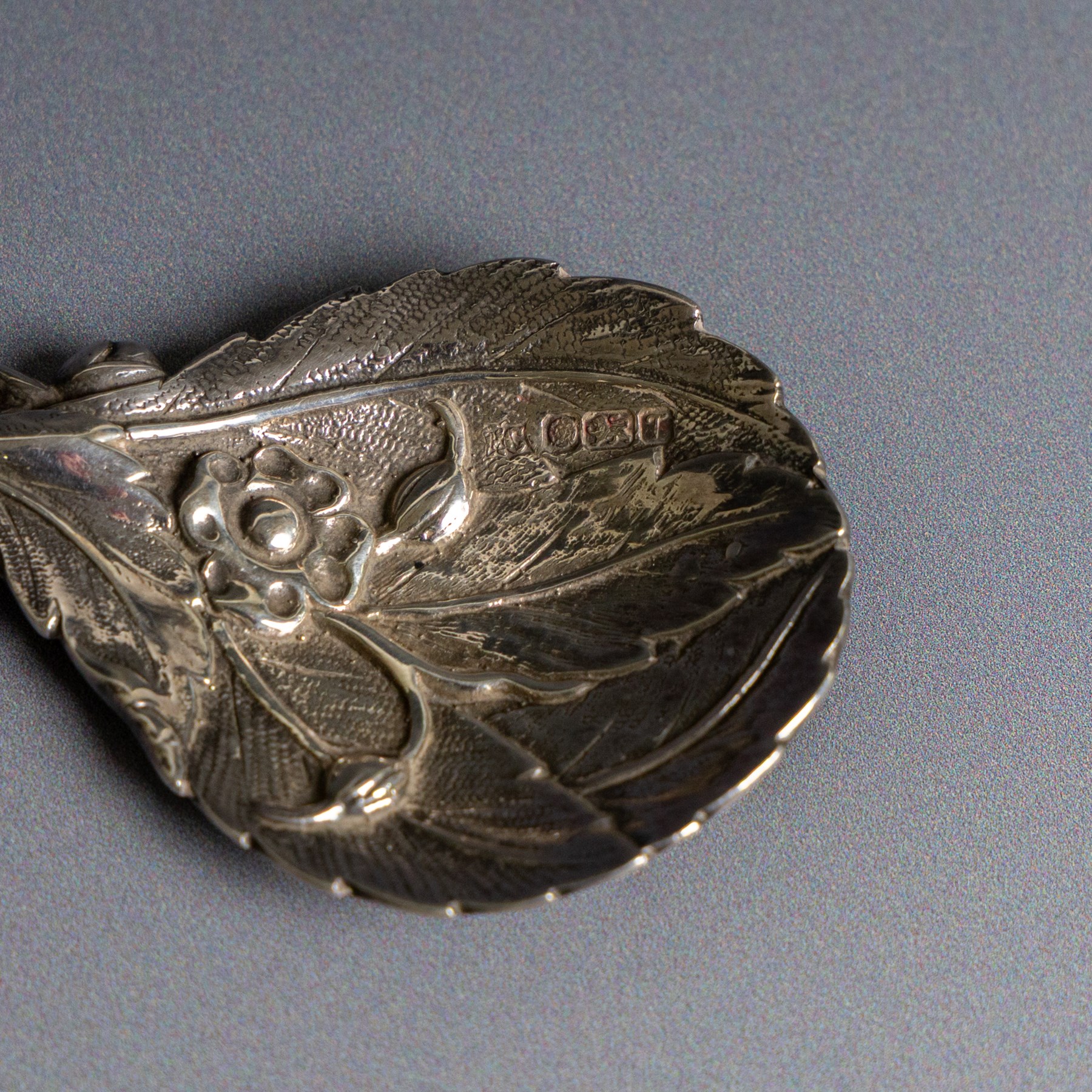 Late 20th century silver caddy spoon, naturalistically modelled with leaf shaped bowl, flowers and buds to centre, hallmarked Sheffield 1993, maker's mark indistinct