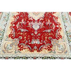 Fine Persian silk inlaid crimson ground Tabriz rug, the shaped field decorated with a central foliate pole medallion filled and surrounded by finely knotted floral motifs and trailing foliage, the cyan guard stripe with bold festoons and palmette motifs