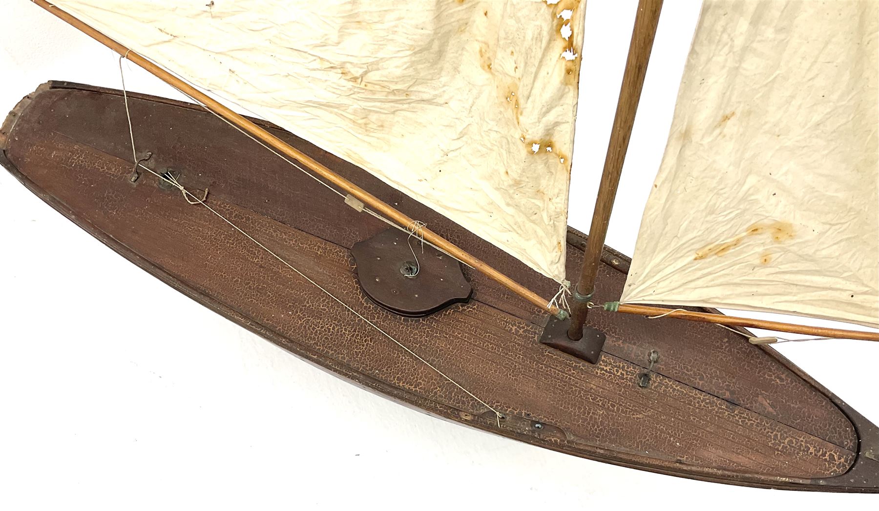 Large Victorian pond yacht, the planked hardwood hull with large lead weighted keel and working rudder, simulated planked deck and single mast with original sails; on later scratch-built wooden stand L117cm H151cm