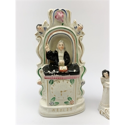 A Staffordshire pulpit group, modelled as John Wesley, H28.5cm, together with another similar Staffordshire example, and a small Staffordshire figure of John Wesley, H14.5cm. 