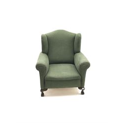 Edwardian wingback armchair, upholstered in a green fabric, ball and claw feet