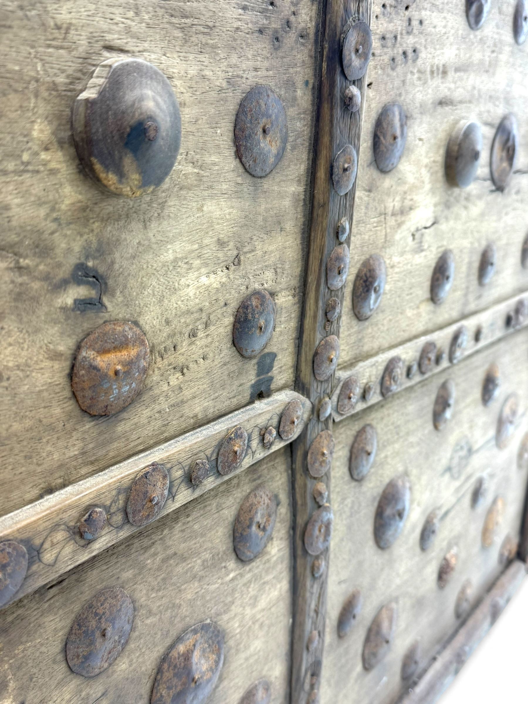 Late 19th century Afghan carved hardwood storage chest, the hinged plank top enclosing large internal storage space, geometric carvings to the front panels decorated with rows of riveted iron bosses