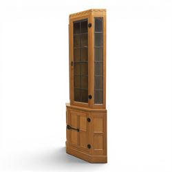 Mouseman - oak floor standing corner cabinet, scalloped cornice above a leaded glass cabinet, blackened metal hinges and latches, with carved mouse by the workshop of Robert Thompson of Kilburn