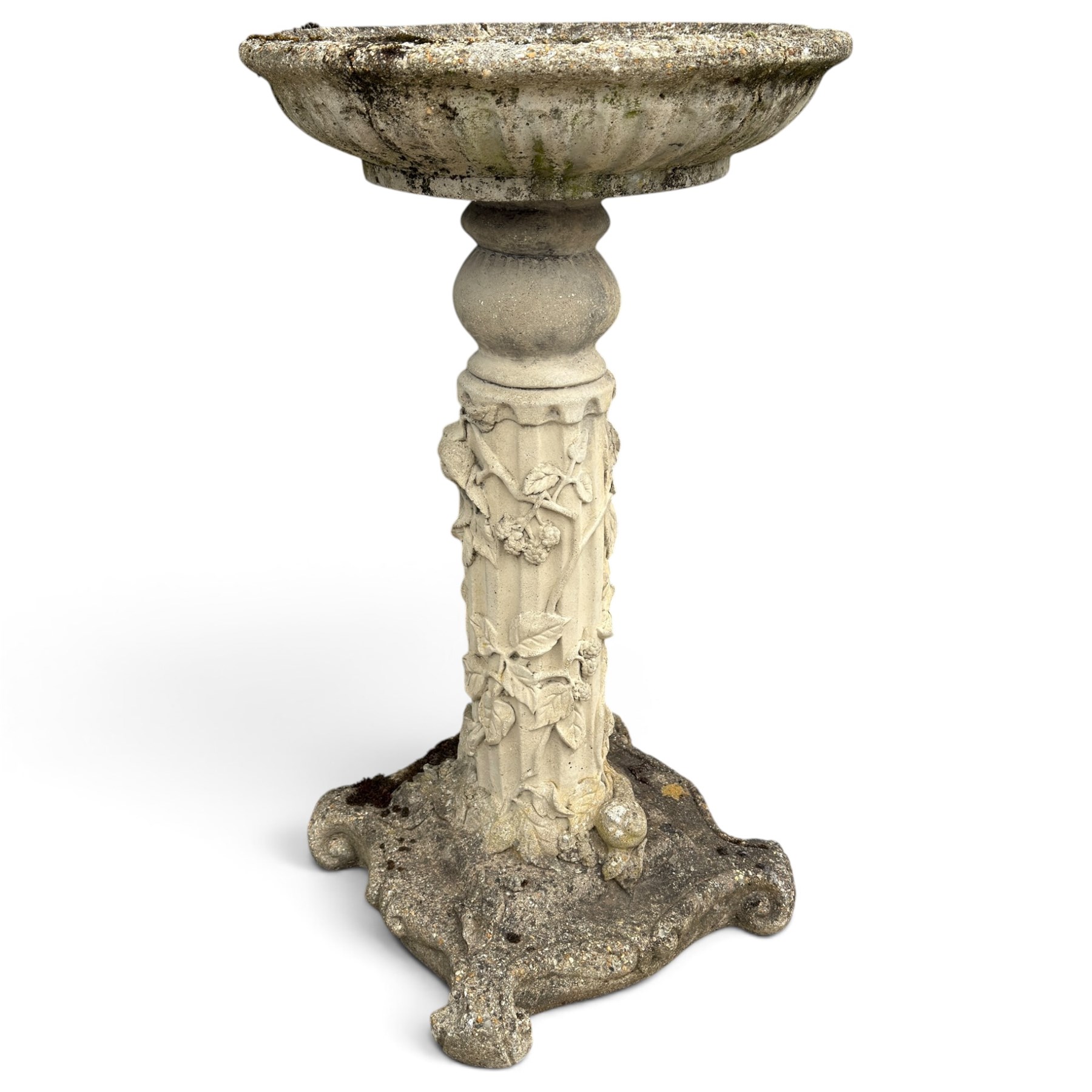 Weathered cast stone birdbath, the kylix shaped bowl with fluted body, raised on a fruiting foliate vine decorated fluted pedestal with upper knop and bird and fieldmouse motifs, shaped square base with scroll feet