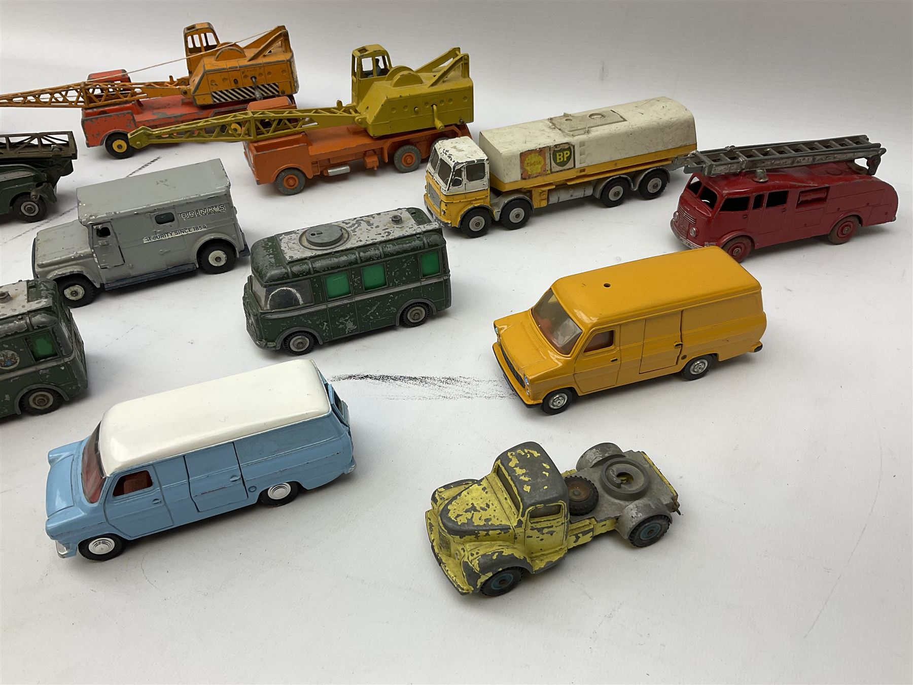 Dinky - thirteen unboxed and playworn die-cast commercial vehicles including two Supertoys 20-Ton Lorry-Mounted Cranes; Leyland Octopus Tanker; Fire Engine No.955; Extending Mast Vehicle No.969; two TV Roving Eye Vans No.968; three Ford Transit Vans; Brinks Armoured Car No.275; etc
